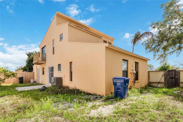 view of property exterior featuring cooling unit and a balcony