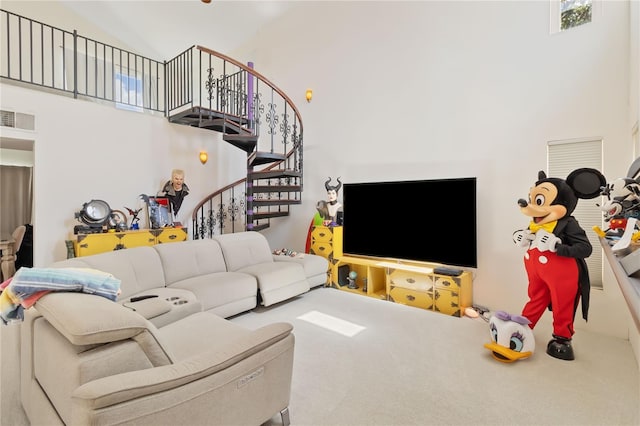 living room with carpet flooring and a towering ceiling