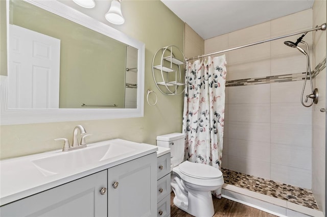 bathroom featuring a shower with curtain, hardwood / wood-style floors, vanity, and toilet