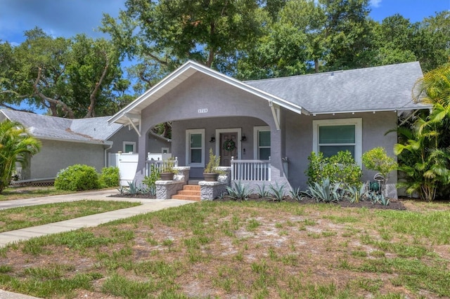 view of front facade featuring covered porch and a front yard