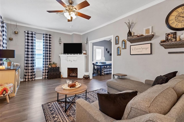 living room with ceiling fan, ornamental molding, dark wood-type flooring, and a brick fireplace