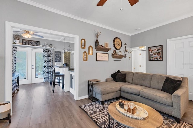 living room with hardwood / wood-style flooring, ceiling fan, crown molding, and french doors