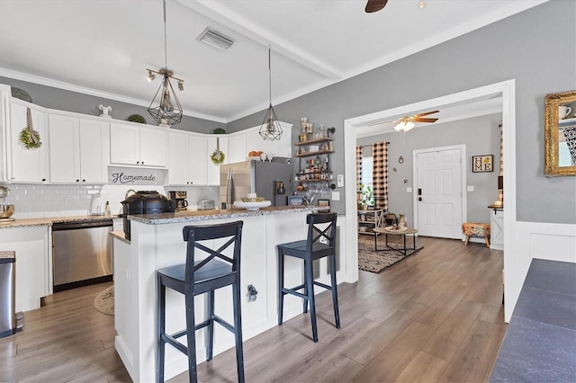 kitchen featuring a breakfast bar area, white cabinetry, hanging light fixtures, and appliances with stainless steel finishes