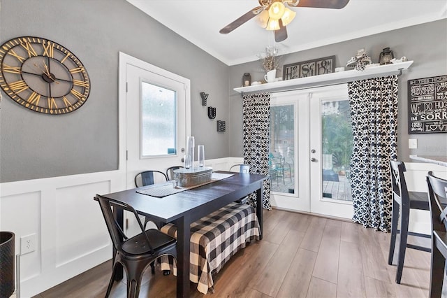 dining room with french doors, hardwood / wood-style flooring, ceiling fan, and crown molding