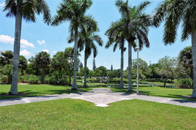 view of home's community with a water view and a yard