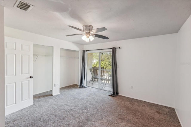 unfurnished bedroom featuring carpet floors, ceiling fan, access to outside, and multiple closets