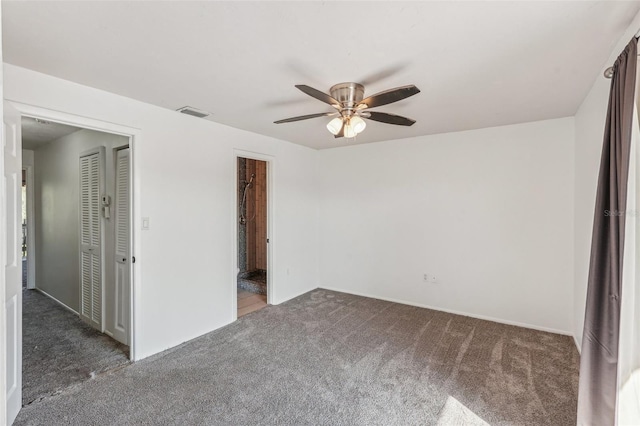 unfurnished bedroom with ceiling fan and dark carpet