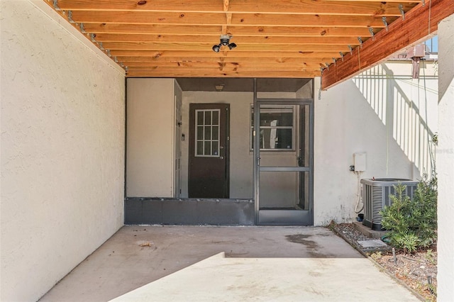 property entrance featuring cooling unit and a patio