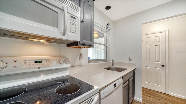 kitchen featuring sink, white appliances, gray cabinets, dark hardwood / wood-style floors, and decorative light fixtures