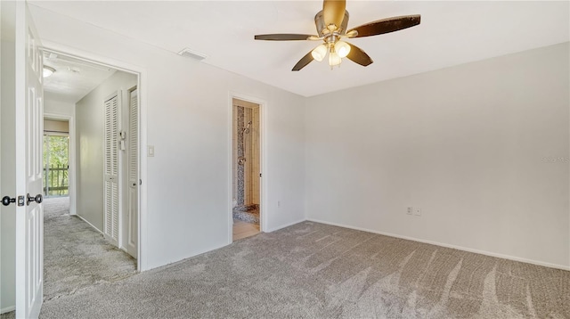 carpeted spare room featuring ceiling fan