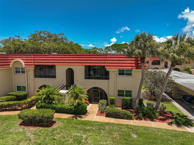 mediterranean / spanish home featuring a front lawn