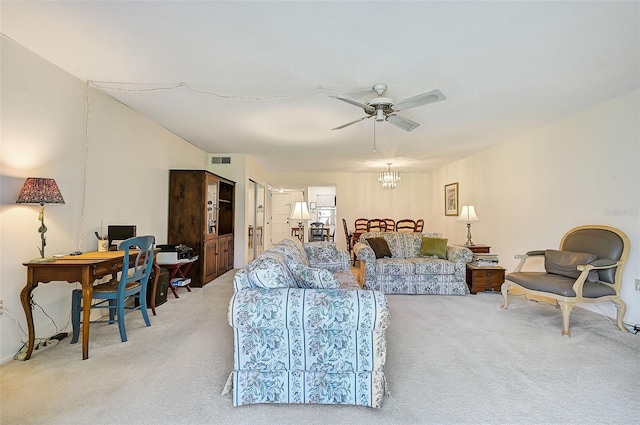 carpeted living room with ceiling fan with notable chandelier