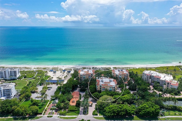 birds eye view of property featuring a water view and a beach view