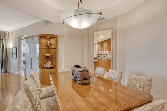 dining area featuring crown molding and light hardwood / wood-style floors