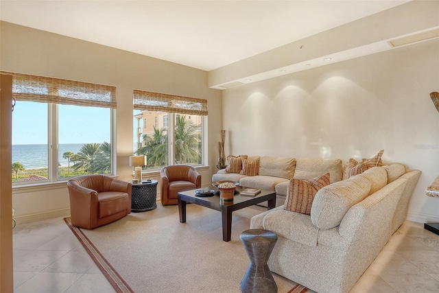 living room with light tile patterned floors and a water view