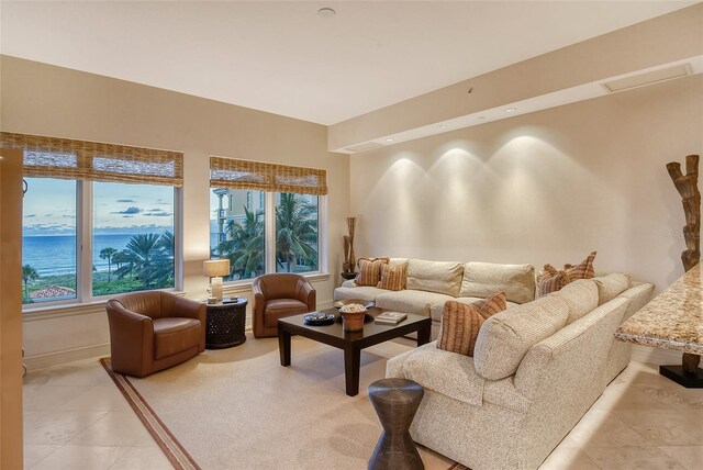 tiled living room featuring a water view