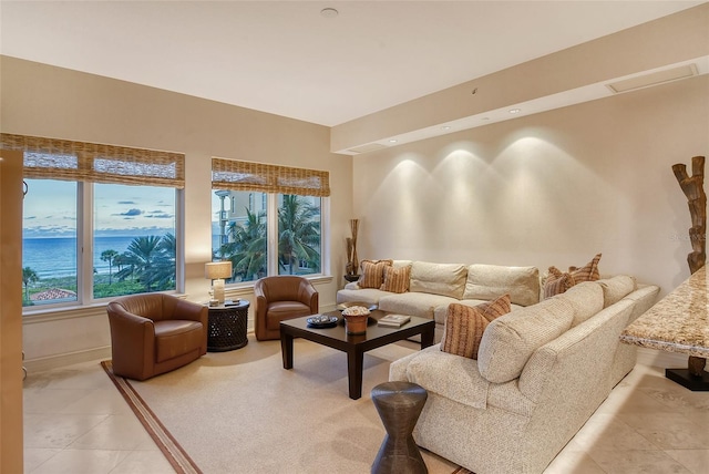 living room with light tile patterned floors and a water view