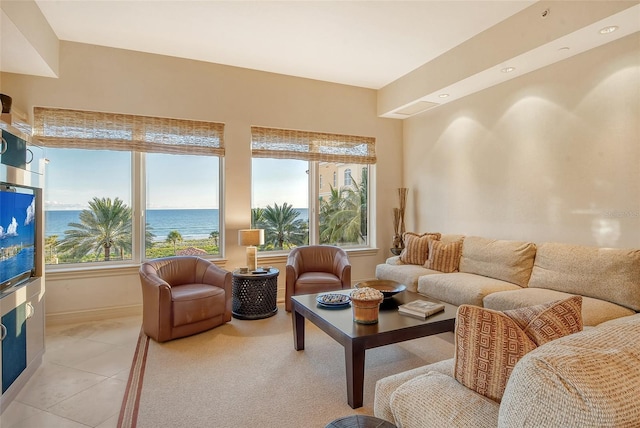 living room featuring light tile patterned floors and a water view