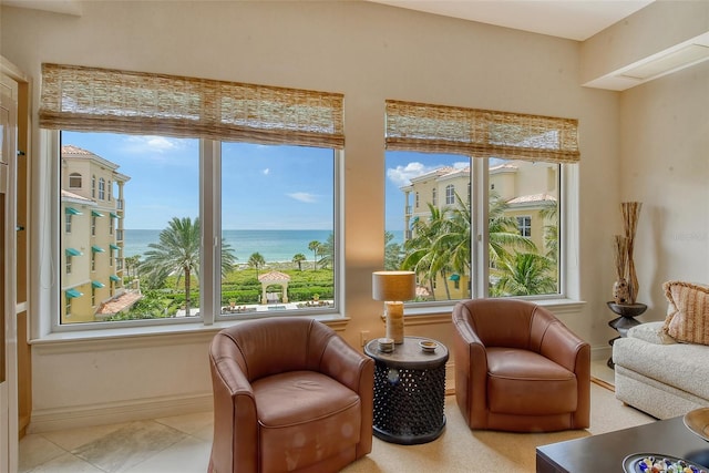 sitting room featuring light tile patterned floors, a wealth of natural light, and a water view