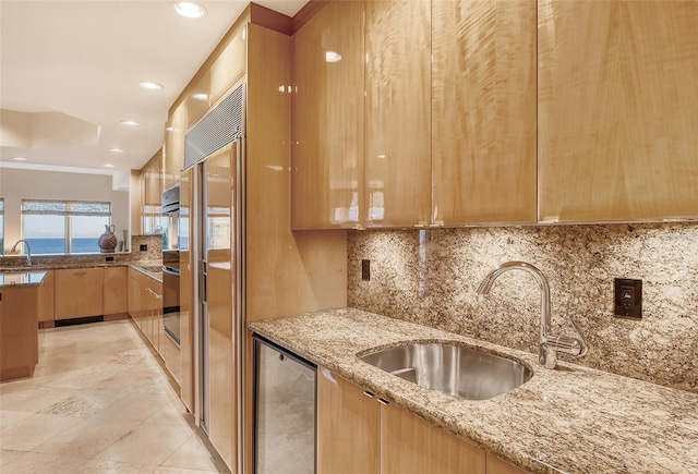 kitchen featuring oven, light stone countertops, sink, light tile patterned floors, and decorative backsplash