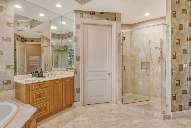 bathroom with tile patterned floors, vanity, and shower with separate bathtub