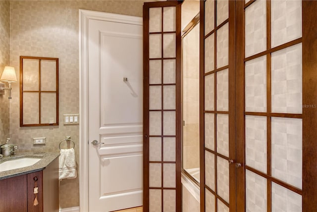 bathroom featuring backsplash, tile walls, french doors, and vanity