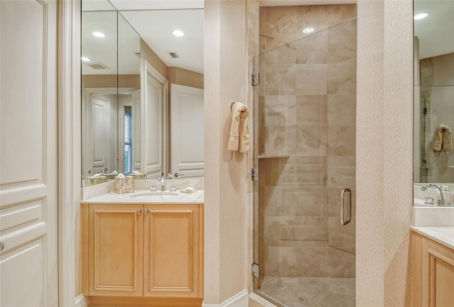 bathroom with a shower with door and vanity