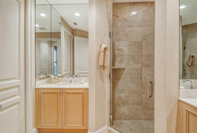 bathroom with vanity and a shower with door