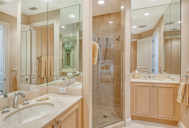 bathroom with an enclosed shower, vanity, and tile patterned flooring