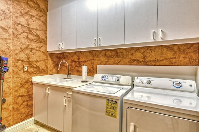 laundry area featuring cabinets, sink, light tile patterned floors, and independent washer and dryer