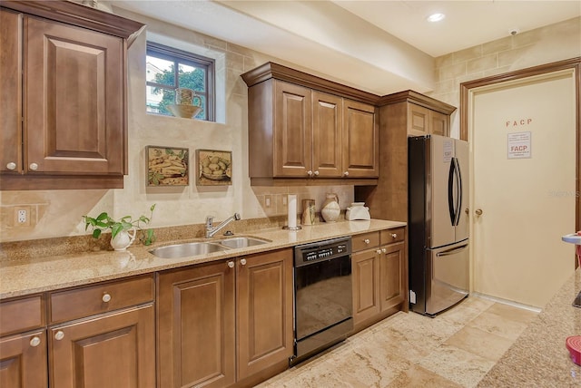 kitchen with sink, light stone countertops, stainless steel refrigerator, and dishwasher