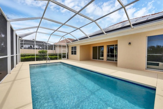 view of pool with glass enclosure and a patio area