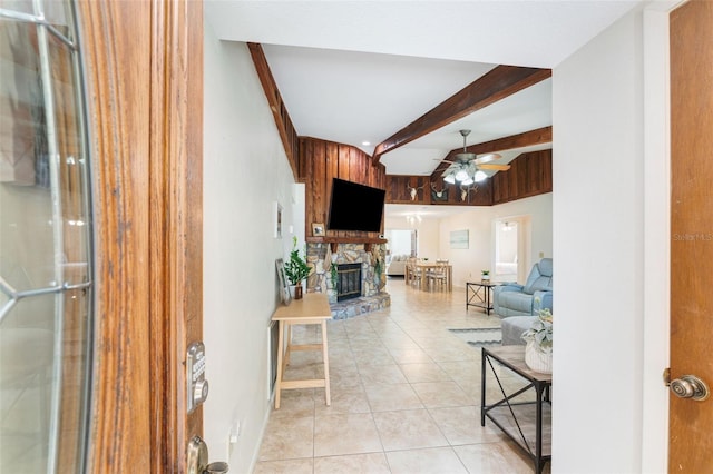 living room with ceiling fan, lofted ceiling with beams, light tile patterned floors, and a fireplace