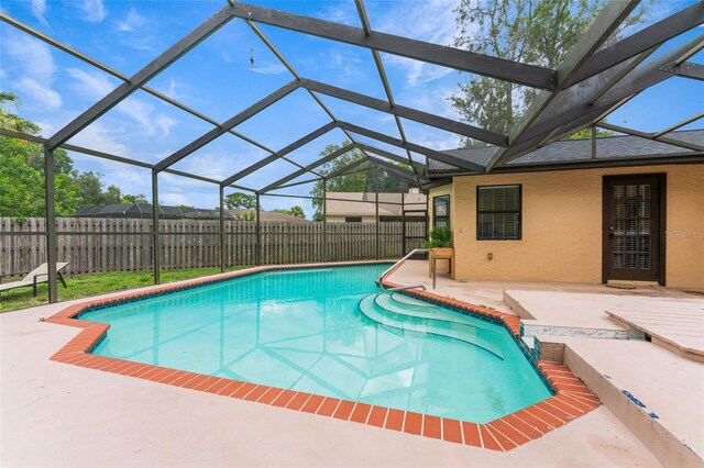 view of pool with glass enclosure and a patio area