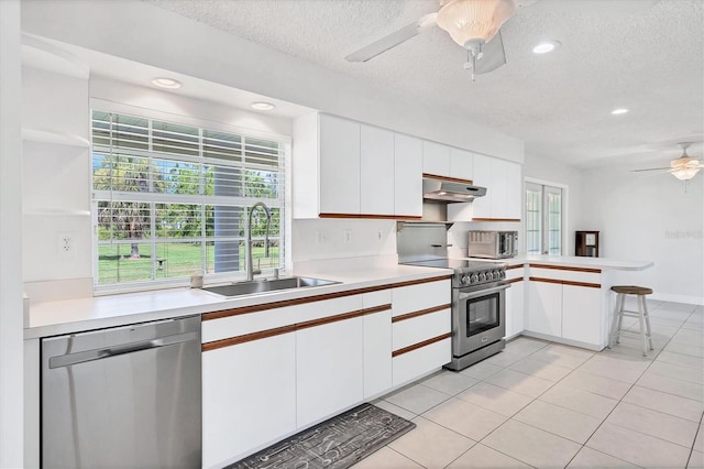 kitchen featuring white cabinets, kitchen peninsula, sink, and appliances with stainless steel finishes