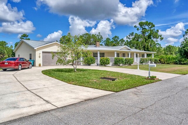 ranch-style home featuring a porch, a garage, and a front lawn