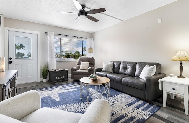 living room featuring a textured ceiling, ceiling fan, and dark hardwood / wood-style floors