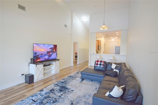 living room featuring light hardwood / wood-style floors and high vaulted ceiling