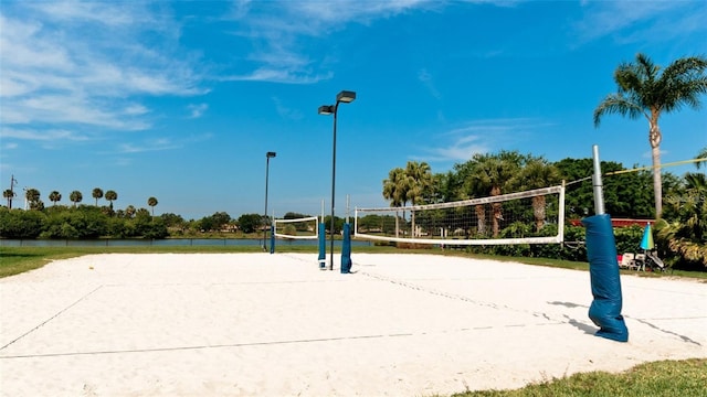 surrounding community with volleyball court and a water view