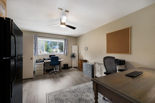 office featuring ceiling fan, light hardwood / wood-style floors, and a textured ceiling