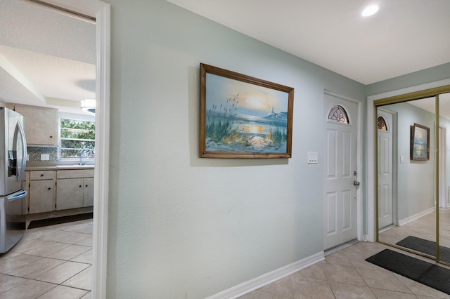 foyer entrance with sink and light tile patterned floors