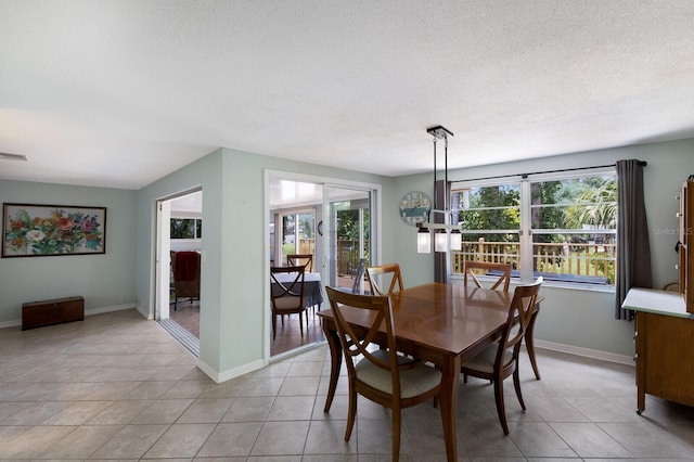 tiled dining area featuring a textured ceiling