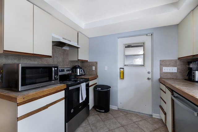 kitchen featuring backsplash, stainless steel appliances, white cabinetry, and light tile patterned flooring