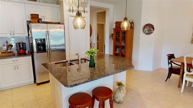 kitchen featuring decorative light fixtures, white cabinetry, sink, and tasteful backsplash