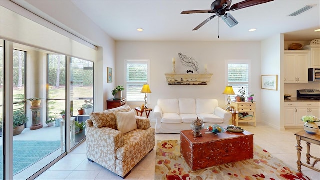 living room featuring plenty of natural light, ceiling fan, and light tile floors