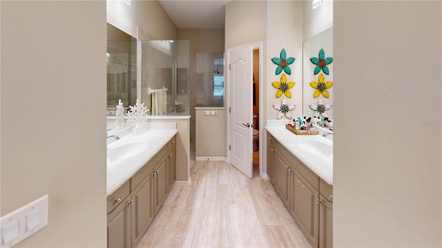 bathroom with wood-type flooring, double vanity, and walk in shower