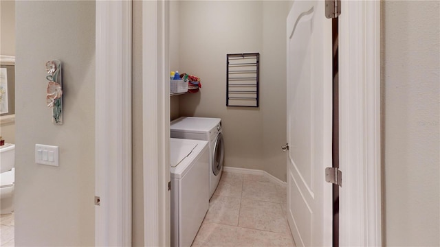 laundry area with washing machine and dryer and light tile floors