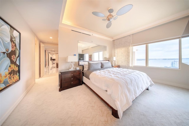 carpeted bedroom with ceiling fan and a water view