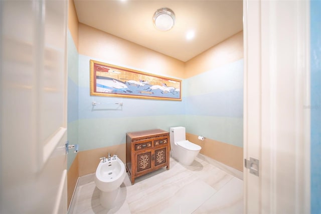 bathroom with tile patterned floors, toilet, and a bidet