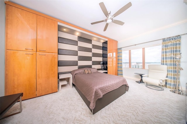 bedroom featuring ceiling fan, a closet, light colored carpet, and ornamental molding